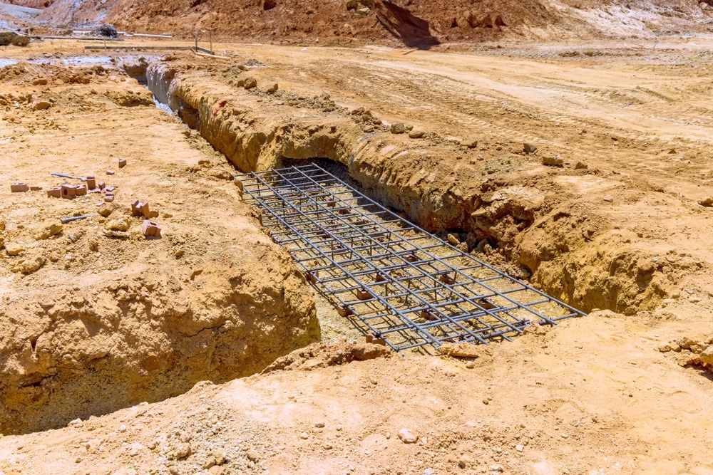 Armature en acier pour fondations de bâtiment sur chantier Cage d'armature en acier installée dans une tranchée de fondation sur un chantier de construction.