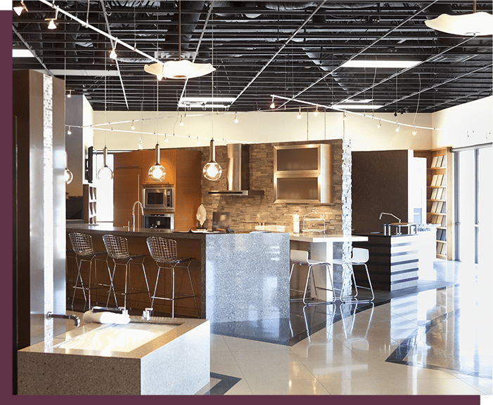 Showroom Cuisine Moderne : Design et Aménagement Intérieur Showroom de cuisine moderne avec îlot central en quartz, tabourets design et luminaires suspendus contemporains.